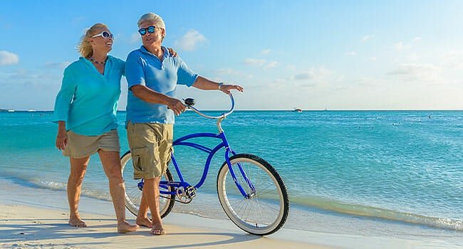 An older couple enjoying a sporty outing on the beach.