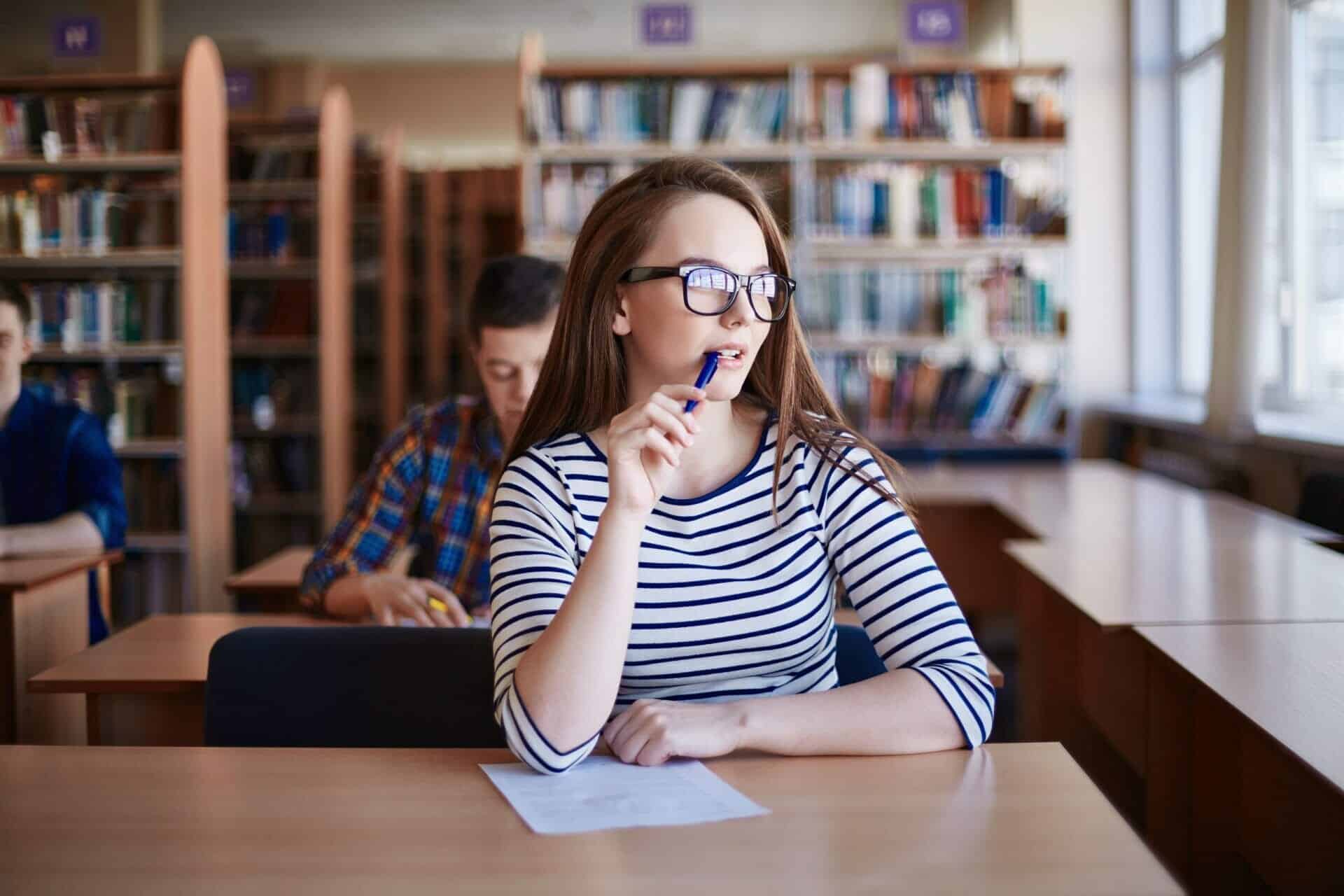 A girl studying at a desk in a library.